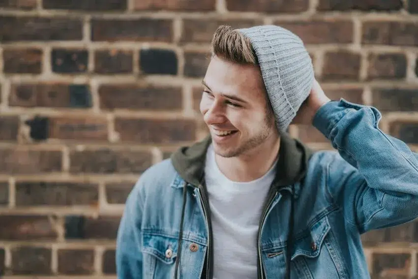 man in gray beanie looking off to the side smiling