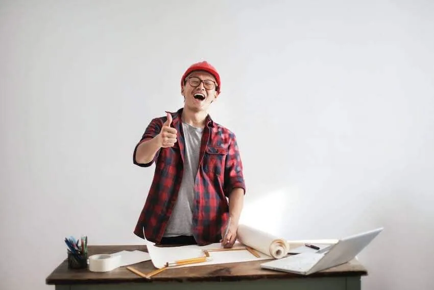 man in red beanie giving a thumbs up