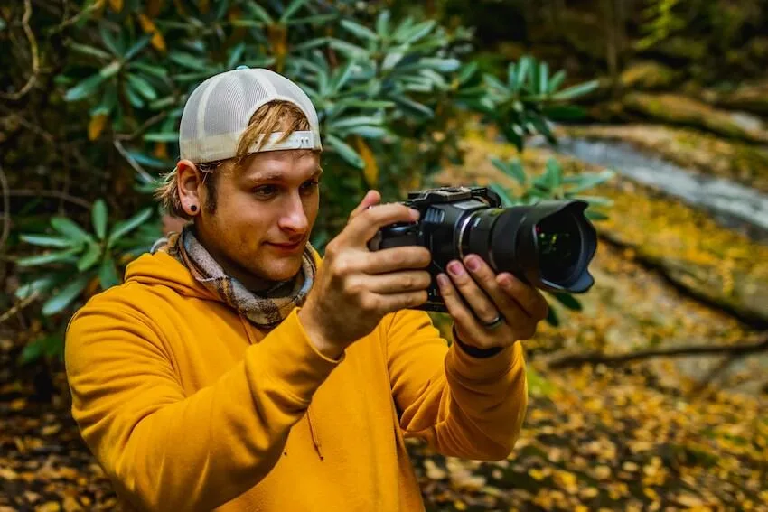 man in yellow sweater taking pictures