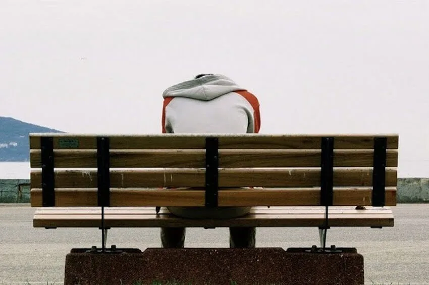 man sitting on a bench with his head down