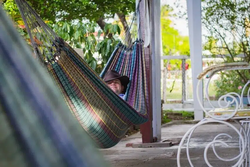 man smiling resting in hammock