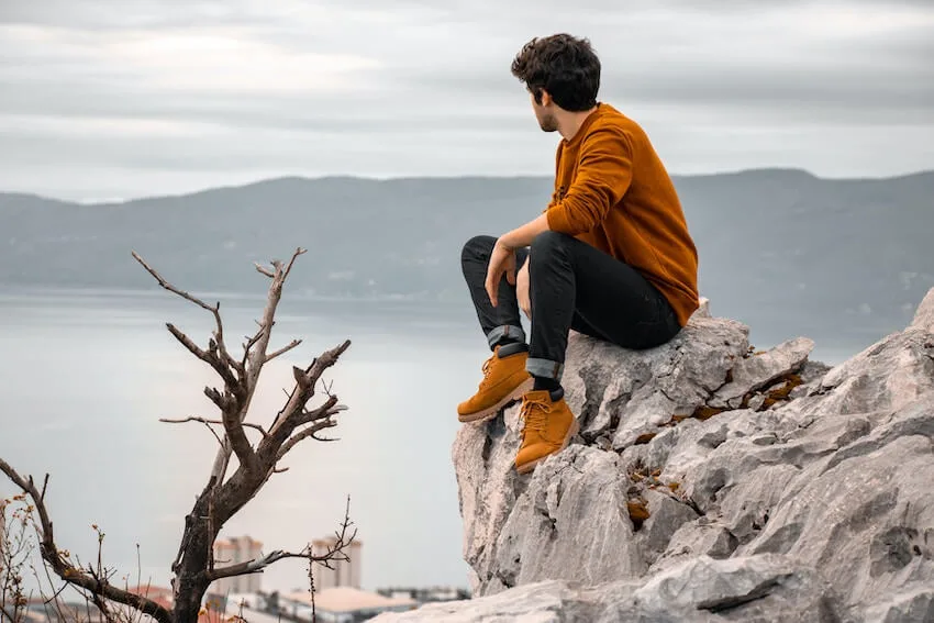 man sitting on a ledge, thinking