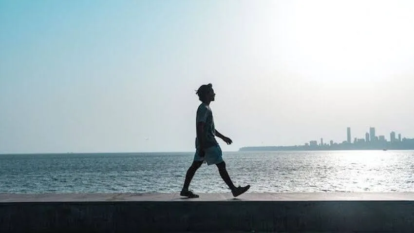 man walking along the shoreline