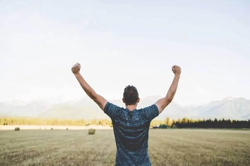 man with his arms up
