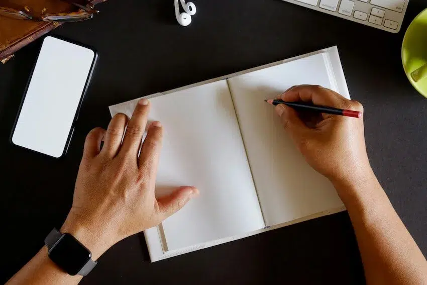 man writing in a journal
