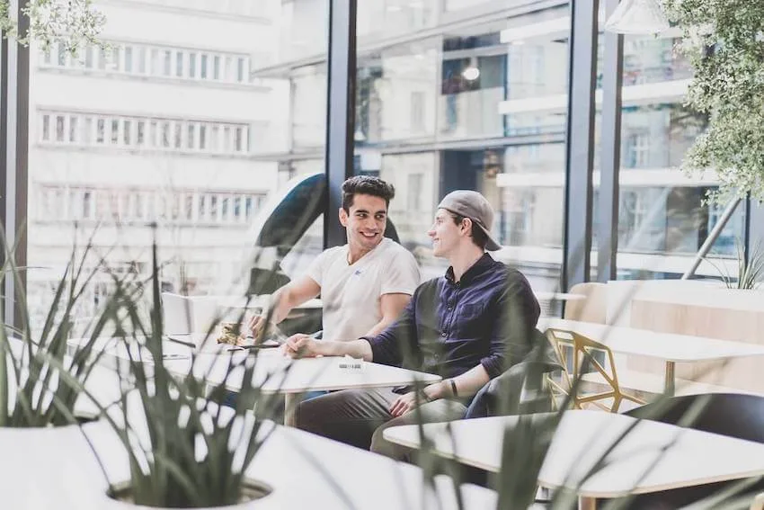 two men sitting at a cafe having a cheerful conversation