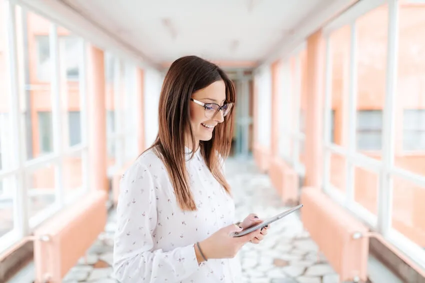 smiling woman learning information on her tablet