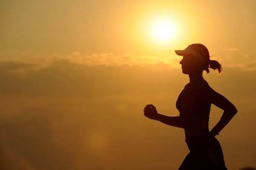 outline of woman running during sunrise