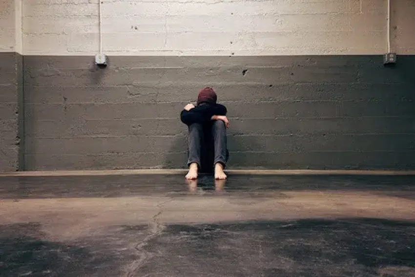 person sitting on the ground with their head down