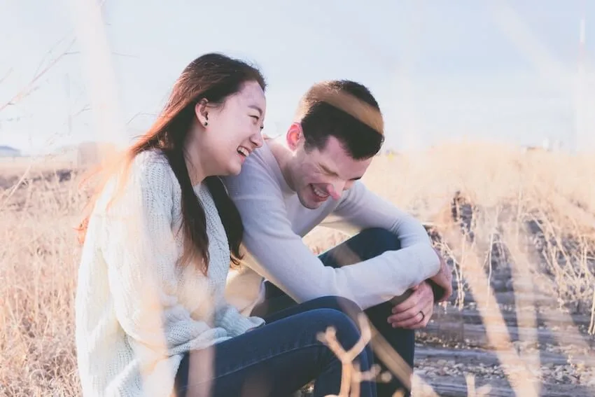 a couple sitting on the ground laughing together
