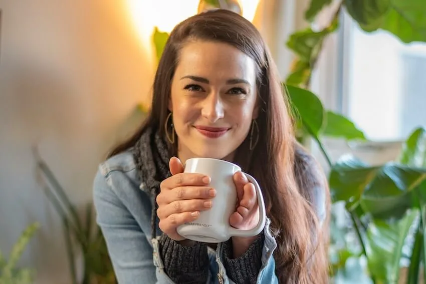 smiling woman holding a coffee mug