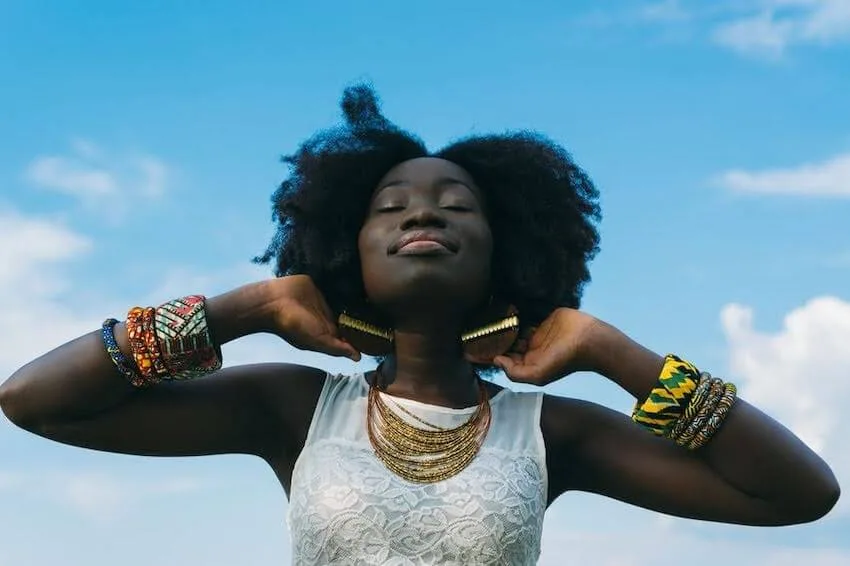 smiling woman with her hands behind her ears