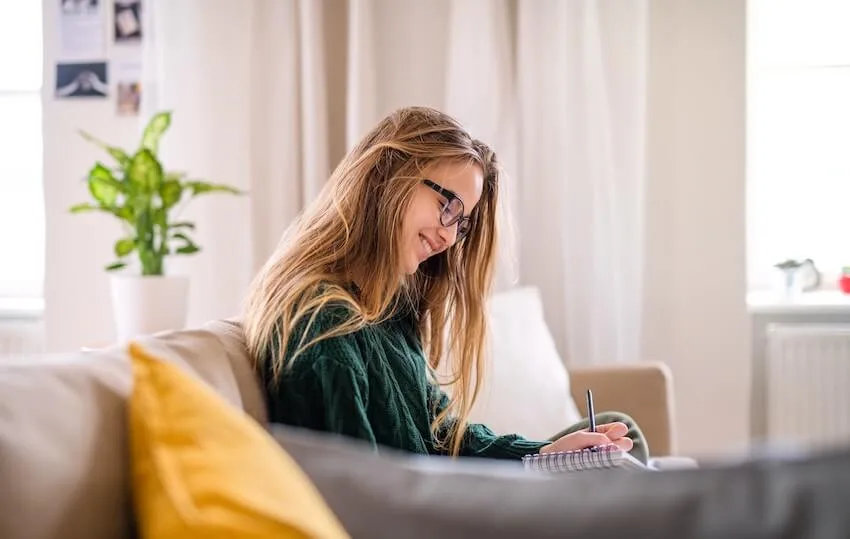 smiling woman writing in a journal