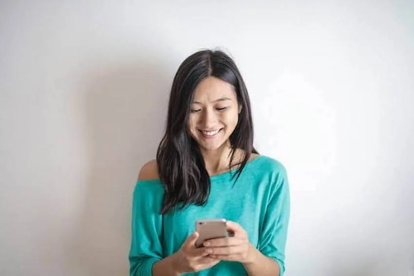 smiling woman sending a text