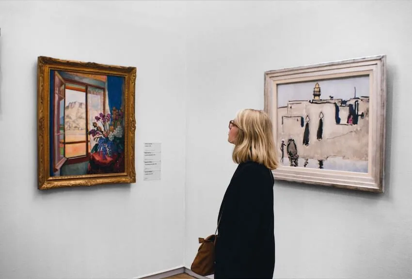 woman looking at paintings in a museum