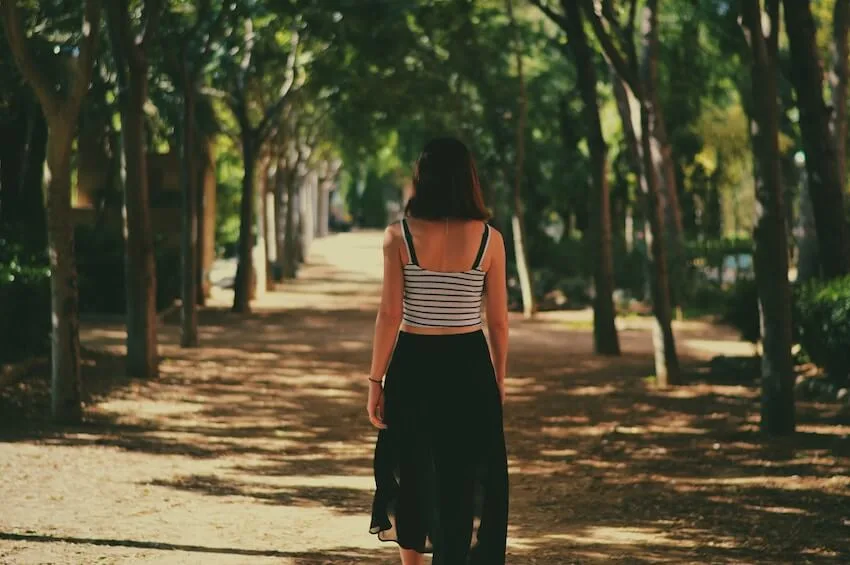 woman walking forward along a path in the woods
