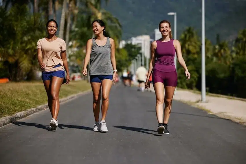 three smiling friends walking outside