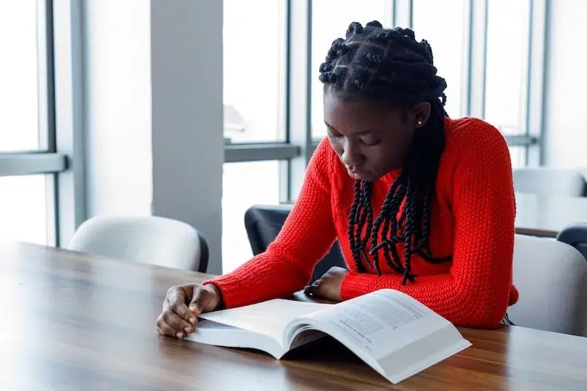 woman in red sweater studying a book