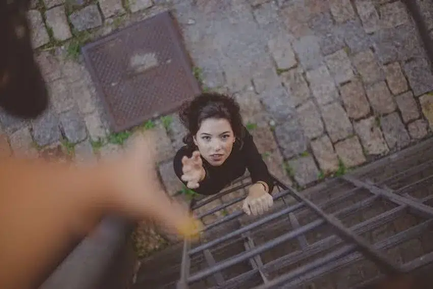 woman reaching for another person's hand