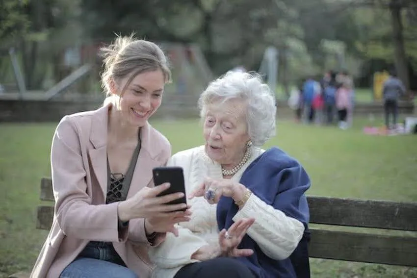 woman sharing good news with her elderly neighbor
