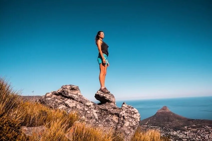 woman standing on top of a rock on top of a mountain