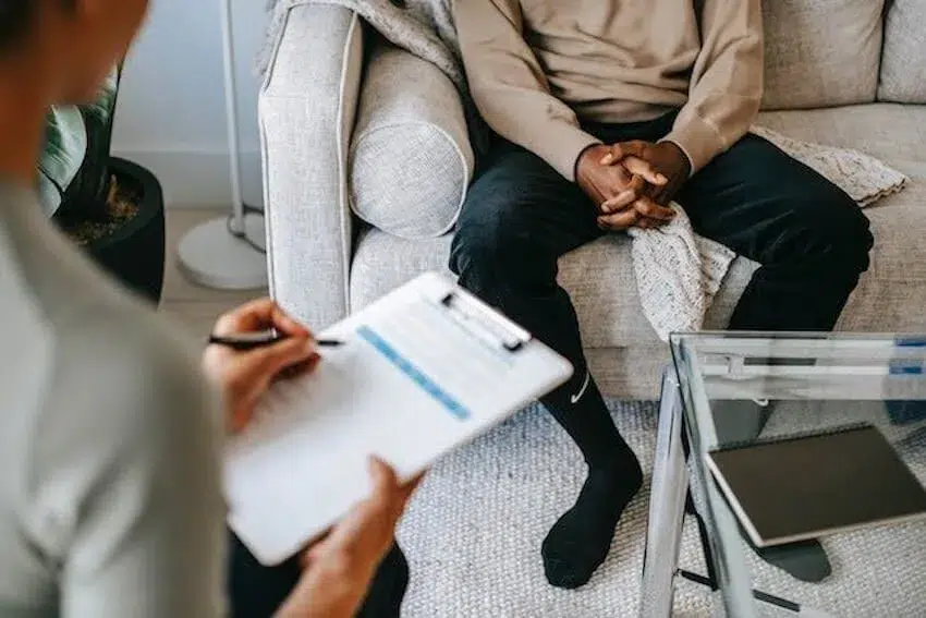 woman taking notes while talking to her patient